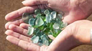 hands-holding-seaglass-on-the-beach